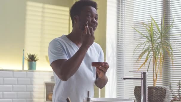 Afro Amerikaanse Man Doet Huidverzorging Procedures Badkamer Aanbrengen Masker Zijn — Stockvideo