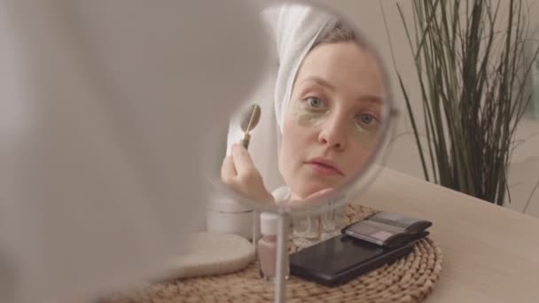 早上淋浴后 年轻美丽的白种女人在水胶眼罩里用石英滚筒按摩脸部 — 图库视频影像