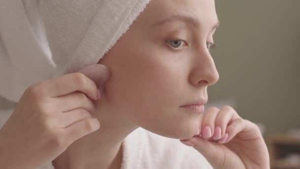若い白人女性は 自宅で風呂の後にフェイスマッサージをしている間 クォーツァンシャーを使用して新鮮なきれいな肌をしています — ストック動画