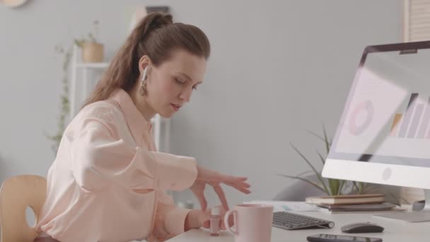 オフィスデスクでデスクトップコンピュータで爪を描く若い白人女性 — ストック動画