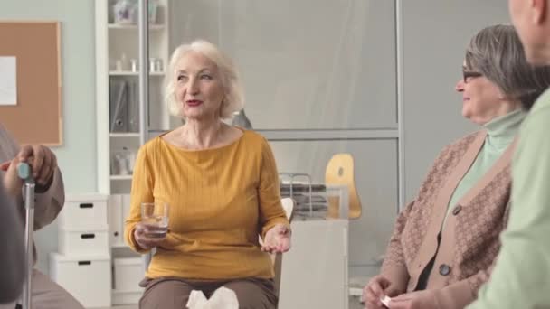 在疗养期间 快乐的老年妇女在舒适的养老院与其他老年人交谈 围坐在一起讨论他们的精神状态 — 图库视频影像
