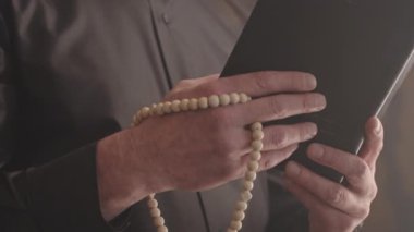 Siyah tişörtlü, beyaz papaz tasmalı, elinde İncil ve tespih boncuklarıyla evde dua okuyan olgun, gri saçlı rahiplerin yavaşlığı.