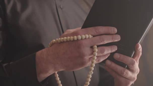 셔츠와 성직자 실내에서 성경과 구슬을 성숙한 사제의 천천히 — 비디오