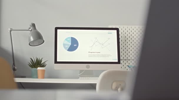 미니멀리즘 사무실에서 데스크톱 컴퓨터 모니터 화면에 회사의 재정적 증가를 보여주는 — 비디오