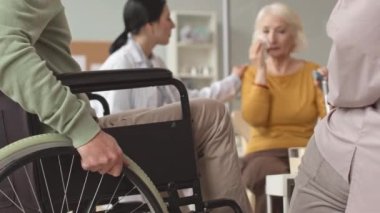 Yaşlılar yurdundaki diğer yaşlılar ve psikologlarla grup terapisi sırasında ağlayan beyaz bir kadın.
