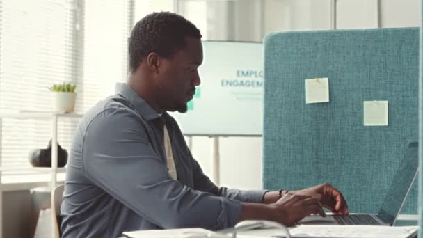 Ung Afroamerikansk Man Arbetar Laptop Ämbetet Dividerat Med Skiljeväggar Mellan — Stockvideo