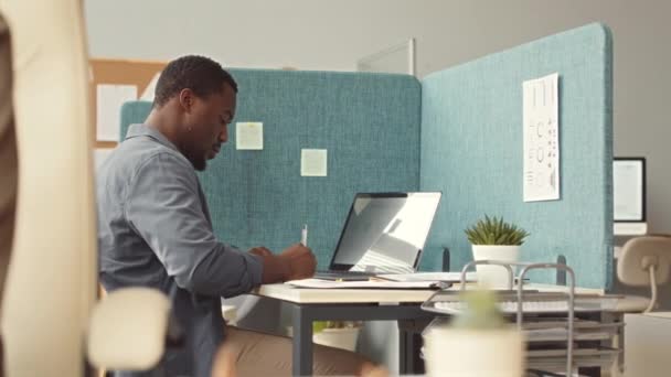 Skupiony Młody Afroamerykanin Piszący Notatki Naklejkach Podczas Pracy Laptopie Współczesnym — Wideo stockowe