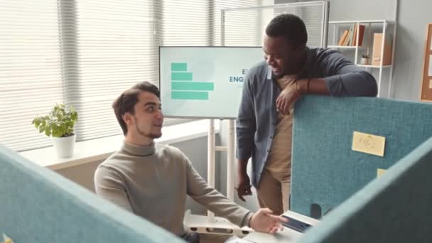 近代的なオフィスで職場で会話する2人の多様な男性の同僚は 隔壁で分割しました — ストック動画