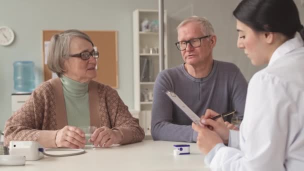 白种人老年夫妇在医生预约期间与年轻女医生交谈 — 图库视频影像