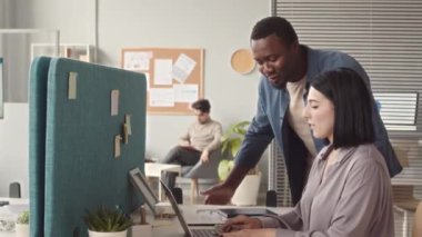 Çok ırklı iki ofis arkadaşı iş yerinde sohbet ediyorlar. Genç ve çekici bir kadın dizüstü bilgisayarında yazı yazarken Afro-Amerikalı erkek arkadaşı masasında durmuş konuşuyor.