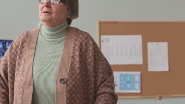 白种人老妇人一边走一边在医生办公室里散步 — 图库视频影像