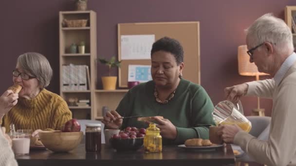 在舒适的疗养院 一群不同种族的老年人在早餐和早餐时聊天 — 图库视频影像