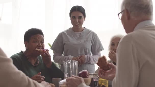 Boomers Multiétnicos Desayunando Juntos Hogar Ancianos Con Enfermeras Jóvenes Cuidándolas — Vídeos de Stock