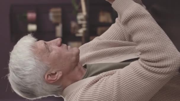 白种人灰发老人坐在养老院餐桌旁与住在那里的其他老年人聊天的垂直镜头 — 图库视频影像