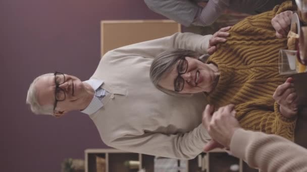 一对快乐的老夫妇在养老院的饭桌上与其他老年人交谈 一边笑一边说话的垂直镜头 — 图库视频影像