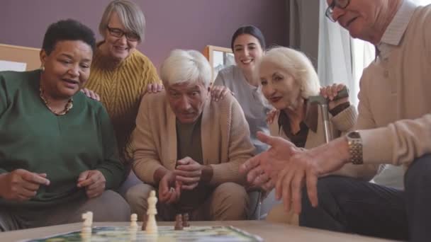 Ethnisch Gemischte Seniorengruppe Würfelt Beim Tischspiel Pflegeheim — Stockvideo