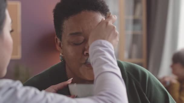 Primer Plano Medio Enfermera Joven Que Alimenta Una Anciana Afroamericana — Vídeo de stock