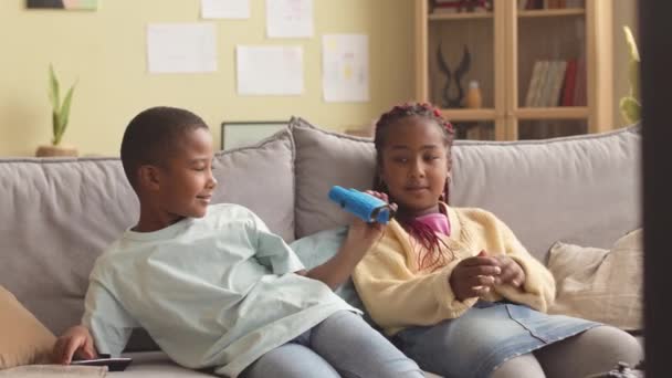 Zwei Afroamerikanische Zwillinge Sitzen Auf Dem Sofa Gemütlichen Wohnzimmer Und — Stockvideo