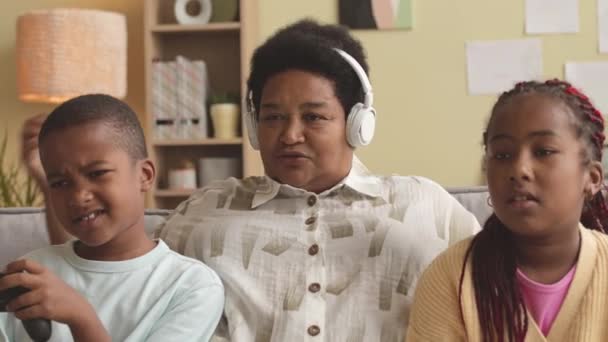 Moderne Erwachsene Schwarze Frau Mit Drahtlosen Kopfhörern Die Ihren Enkeln — Stockvideo