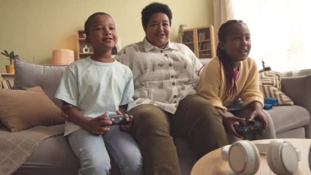 Dos Hermanos Afroamericanos Abuela Moderna Jugando Videojuegos Juntos Sofá Sala — Vídeo de stock