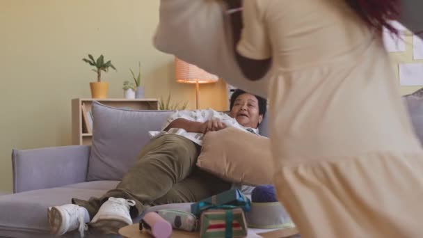 アフリカ系アメリカ人の祖母と 一緒に楽しく暮らすリビングルームで戦う孫の枕の2つの遊び心のあるタトゥー — ストック動画