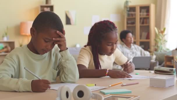 Afro Amerikalı Ilkokul Öğrencisi Oturma Odasında Çalışma Kağıtları Okuyorlar Gündüzleri — Stok video