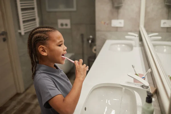 Küçük Siyah Bir Kızın Pembe Diş Fırçasıyla Dişlerini Fırçalarkenki Portresi — Stok fotoğraf