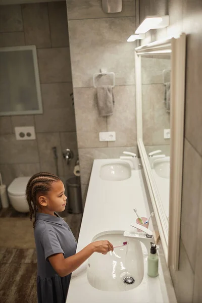 Küçük Siyah Kızın Dikey Portresi Pembe Diş Fırçasıyla Dişlerini Fırçalarken — Stok fotoğraf