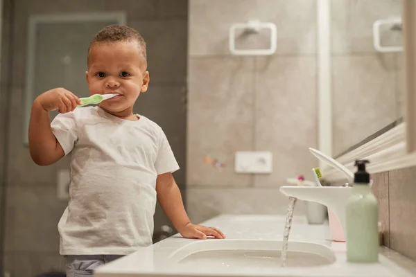 トイレで歯を磨き カメラを見て スペースをコピーする黒い幼児の男の子の肖像画 — ストック写真