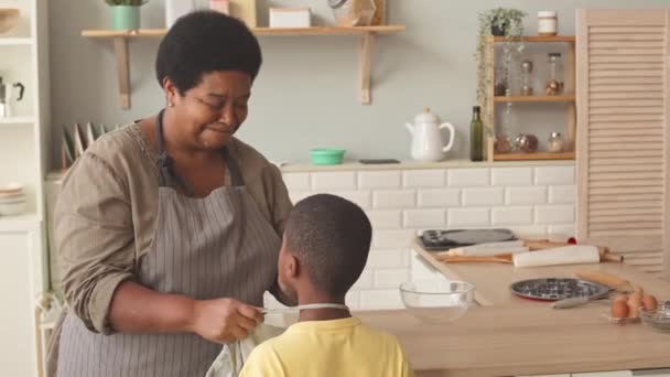 Nenek Afrika Amerika Mengikat Celemek Pinggang Cucunya Ketika Sedang Bersiap — Stok Video