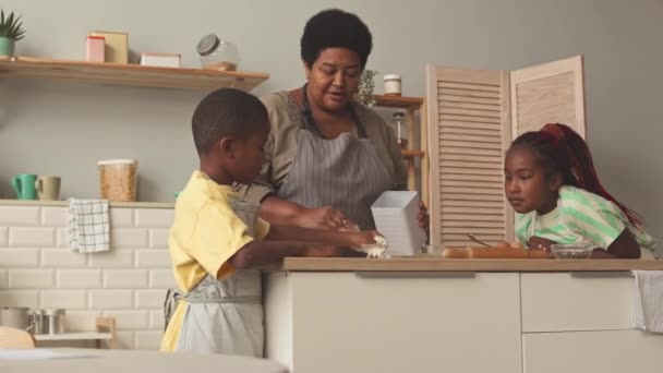 Африканська Американська Бабуся Кидає Борошно Кухонний Стіл Роблячи Тісто Онуками — стокове відео