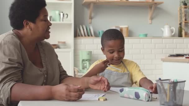 Słodkie Afroamerykanin Mały Chłopiec Studia Matematyki Babcia Siedzi Razem Kuchni — Wideo stockowe