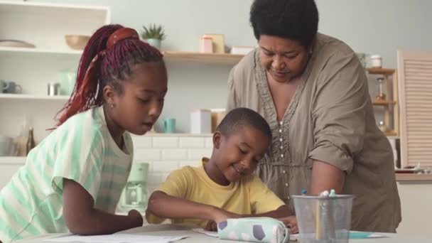 Африканська Американська Бабуся Допомагає Двом Онукам Шкільним Домашнім Завданням Навчаючись — стокове відео