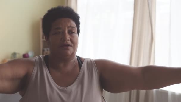 ホームワークアウト中にダンベルで運動する成熟したアフリカ系アメリカ人女性を決定 — ストック動画