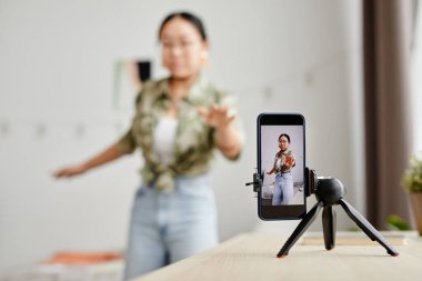 Sosyal medya için video çeken Asyalı genç kızın arkaplan görüntüsü, akıllı telefon ekranına odaklan, boşluğu kopyala