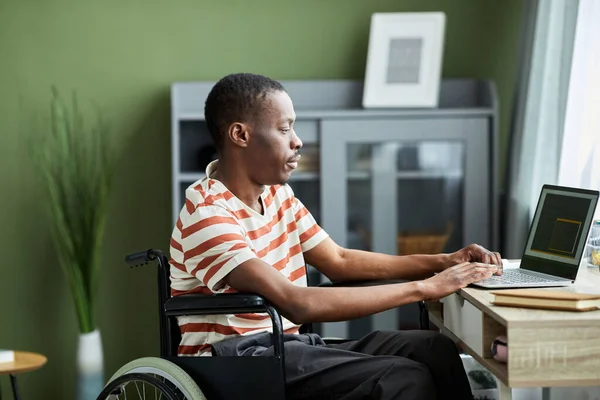 Widok Boku Portret Afroamerykanina Niepełnosprawnością Przy Użyciu Laptopa Podczas Pracy — Zdjęcie stockowe