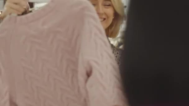 在设计师陈列室买衣服时 快乐的金发女人在柜台边对店员笑着 — 图库视频影像