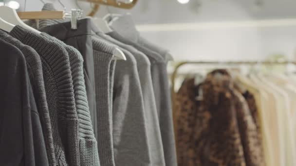 奢侈品商店里没有人在衣架上挂着高质量的灰色针织物 — 图库视频影像