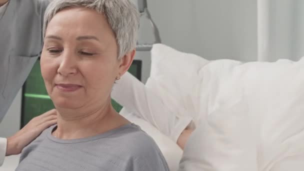 Enfermeira Cuidadora Irreconhecível Ajudando Mulher Asiática Sênior Deitada Cama Quarto — Vídeo de Stock