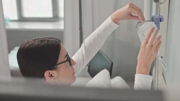 若い女性看護師が病院の患者にドロッパーを設定 — ストック動画