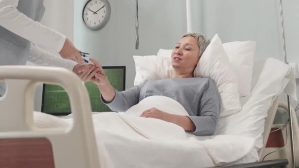 Медсестра Вимірює Насиченість Кисню Старшої Азіатки Лежачи Лікарняному Ліжку Використовуючи — стокове відео