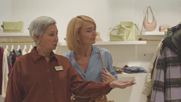 Bayan Mağaza Danışmanı Müşteriye Tasarımcı Butiğini Gezdiriyor Yeni Kıyafet Aksesuar — Stok video