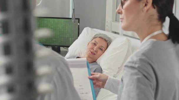 Sick Mature Asian Woman Talking Doctor Nurse While Lying Hospital — Stock Video