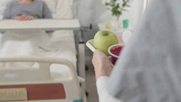 Неузнаваемая Медсестра Приносит Здоровый Завтрак Пациенту Лежащему Больничной Койке — стоковое видео