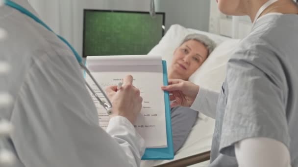 Tiro Cortado Médico Masculino Irreconhecível Jaleco Branco Preenchendo Cartão Médico — Vídeo de Stock