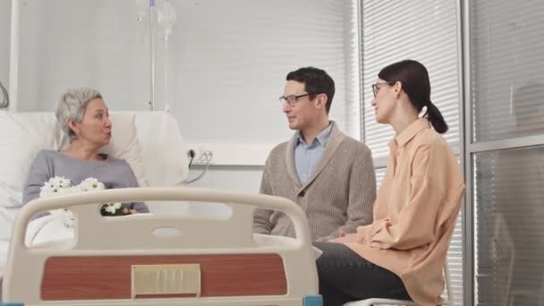 Zwei Erwachsene Kinder Besuchen Ihre Geliebte Mutter Krankenhauszimmer Sitzen Ihrem — Stockvideo
