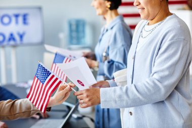 Gülümseyen kadının seçim günü oy pusulasını Amerikan bayrağıyla çekmesi, kopyalama alanı