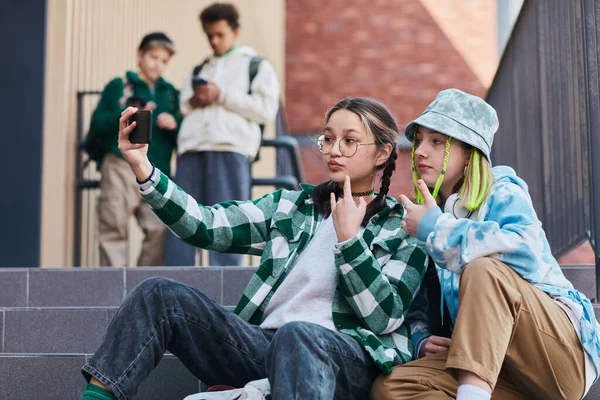 Två Tonårstjejer Sitter Trappor Skolbyggnaden Och Gör Selfie Porträtt Smartphone — Stockfoto