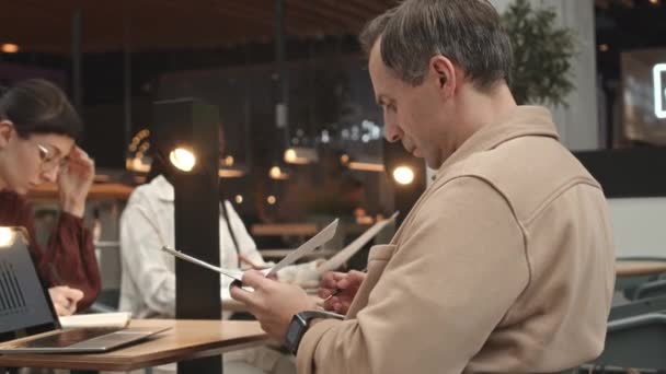リモートで働く現代のカフェでテーブルに座っている多様な人々 — ストック動画