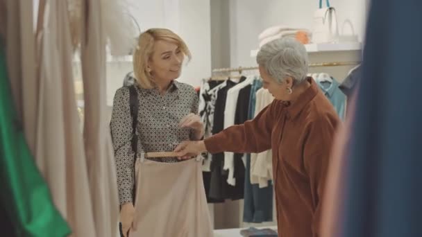 Дві Елегантні Зрілі Жінки Купують Разом Дизайнерському Бутіку Приміряючи Одяг — стокове відео